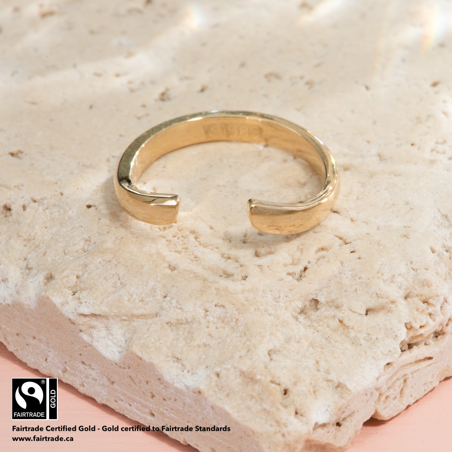 A blunt, open chevron ring of polished yellow gold.