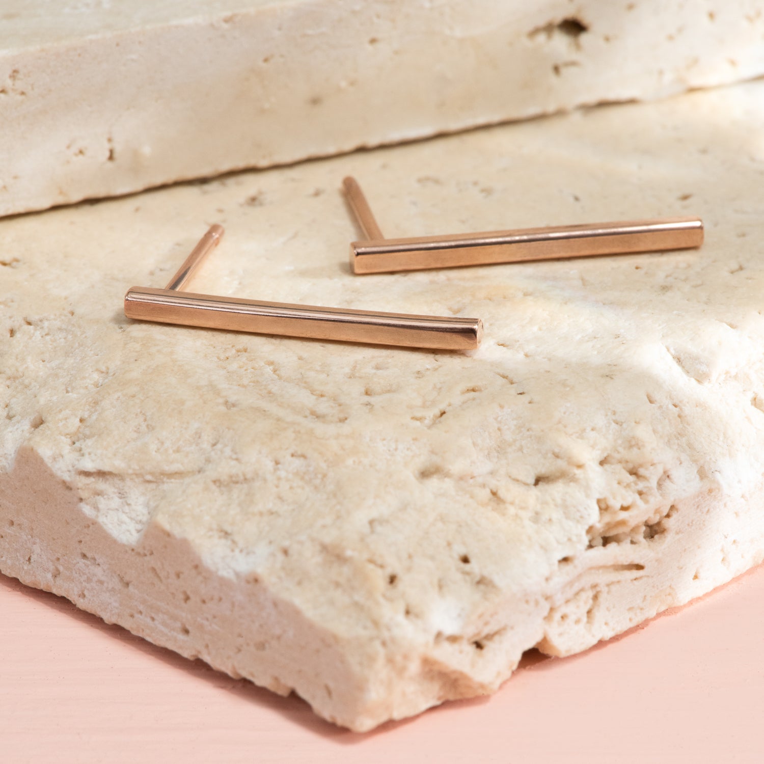 Long, thin, rectangular stud earrings in high polish rose gold.