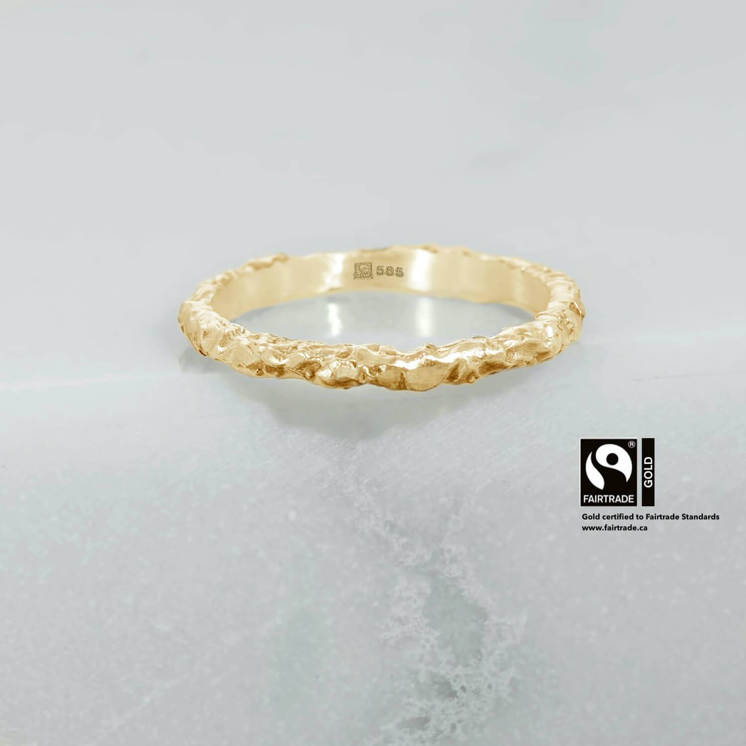 This ring is handcrafted using 14 karat yellow Fairtrade Certified gold. It has concave, carved features along the profile with a satin finish. The ring measures 1.5mm in its width & 1.3mm in its thickness.