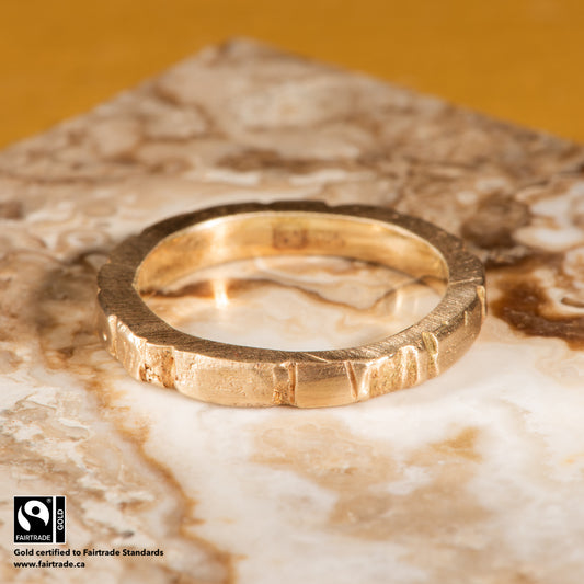 14 karat Fairtrade Certified yellow gold wedding ring with a carved profile, brought to a high polish. The ring is engraved with the Fairtrade logo and hallmarked 585.