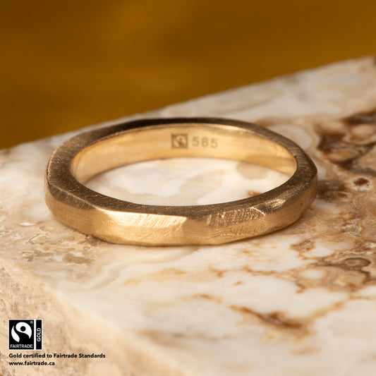 14 karat Fairtrade Certified yellow gold wedding ring with a graduated facet texture with a satin finish. The wedding ring is 4.2mm in width & 2.5mm in thickness.The ring is engraved with the Fairtrade logo and hallmarked 585.
