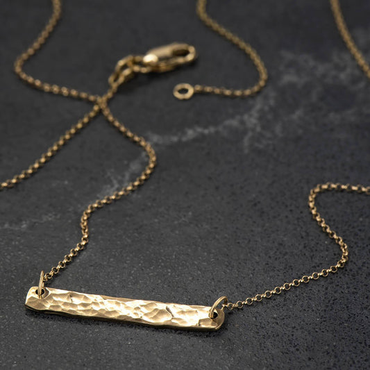 10 karat recycled yellow gold hammer finished bar pendant brought to a polished finish with a 19" rolo chain
