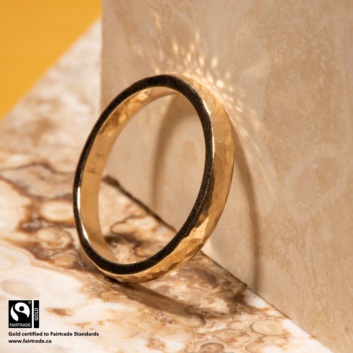 14 karat Fairtrade Certified yellow gold ring with a ball peen hammer finish brought to a high polish. The ring is engraved with the Fairtrade logo and hallmarked 585.