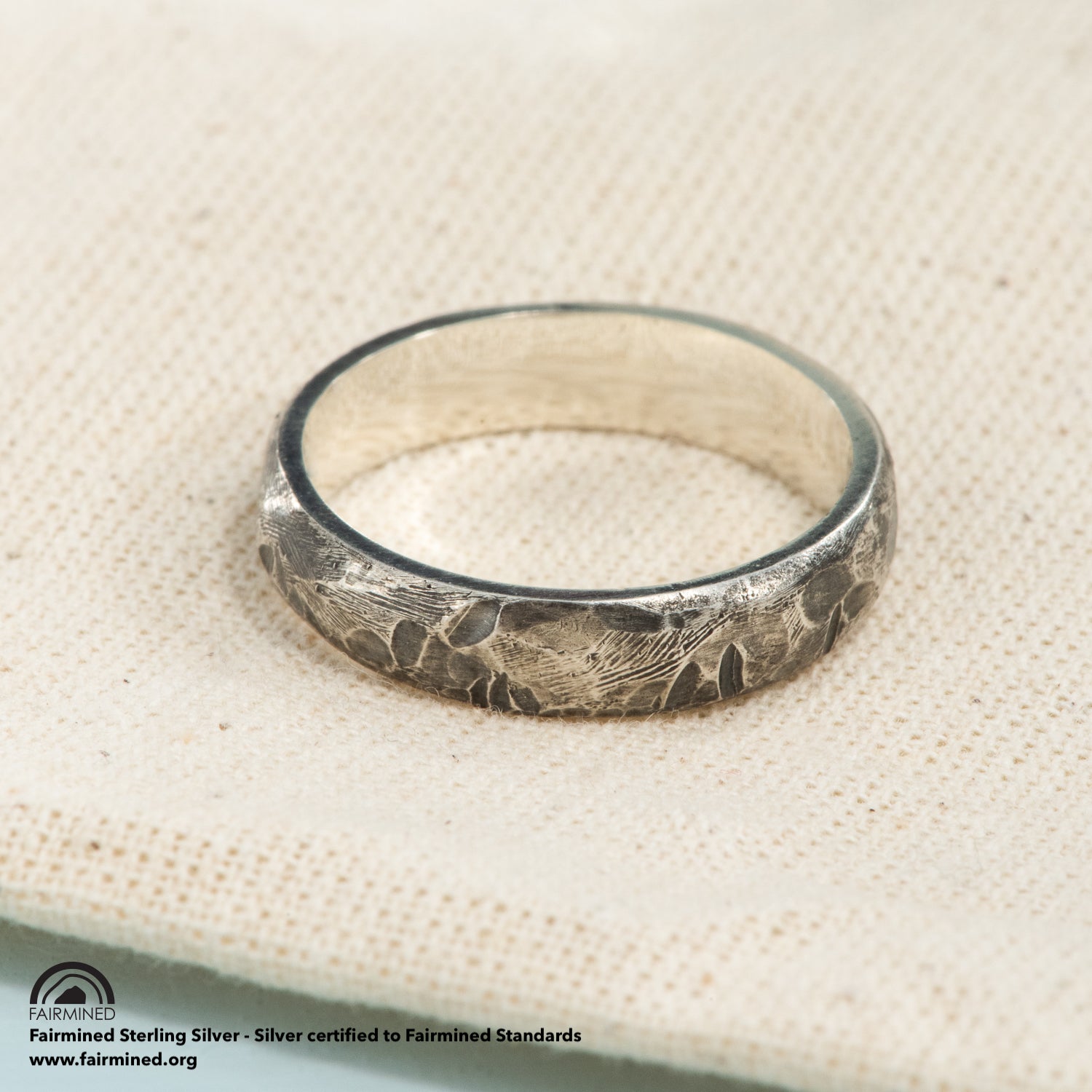 A silver ring with a light oxidized and hammered finish. 