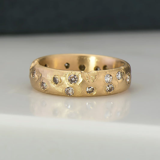 Recycled 14 karat yellow gold wedding band. This ring contains 20, 2mm natural round diamonds in which have been set in cast. The band is 5mm in width and 1.5mm in thickness.