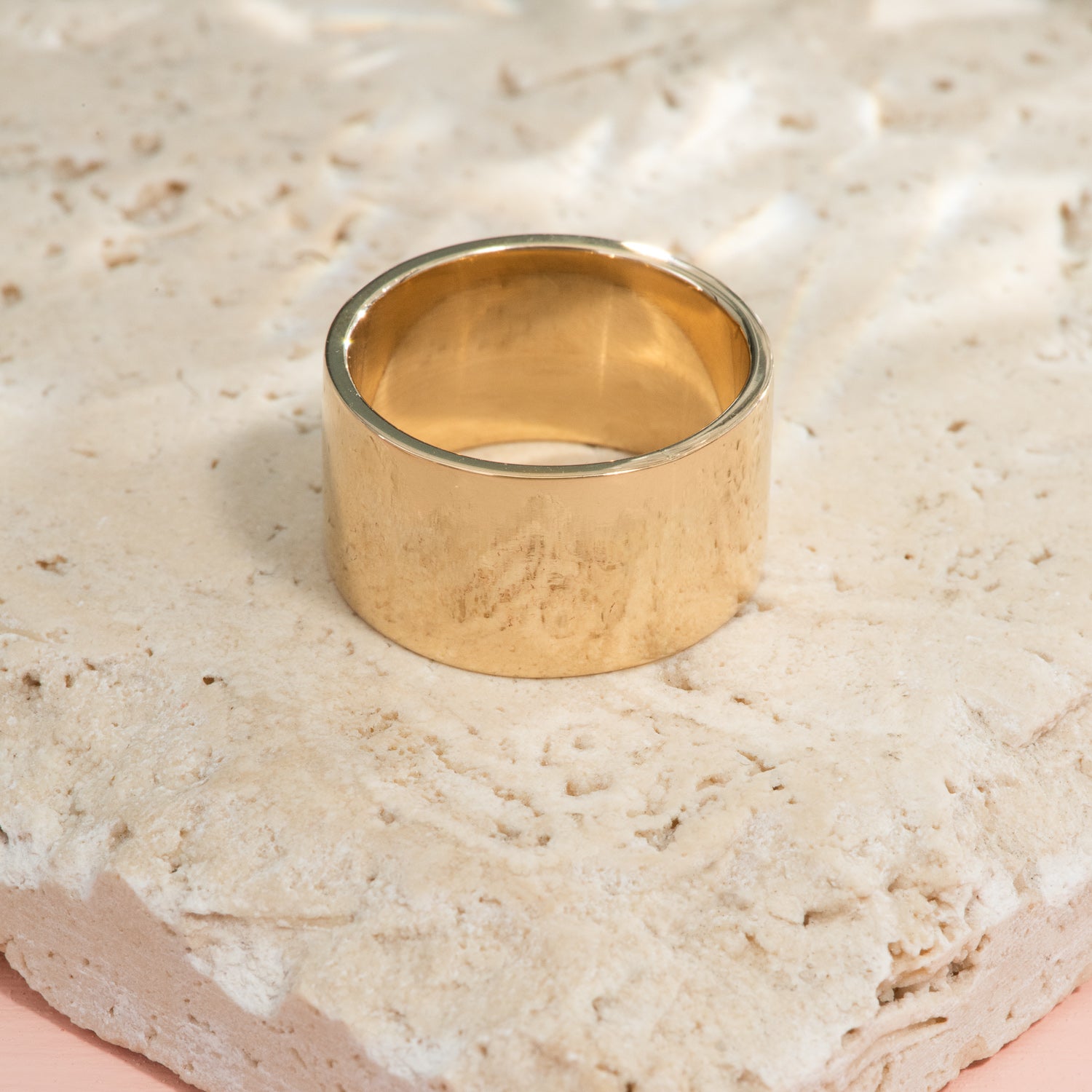 A wide, flat, high polish ring of yellow gold.