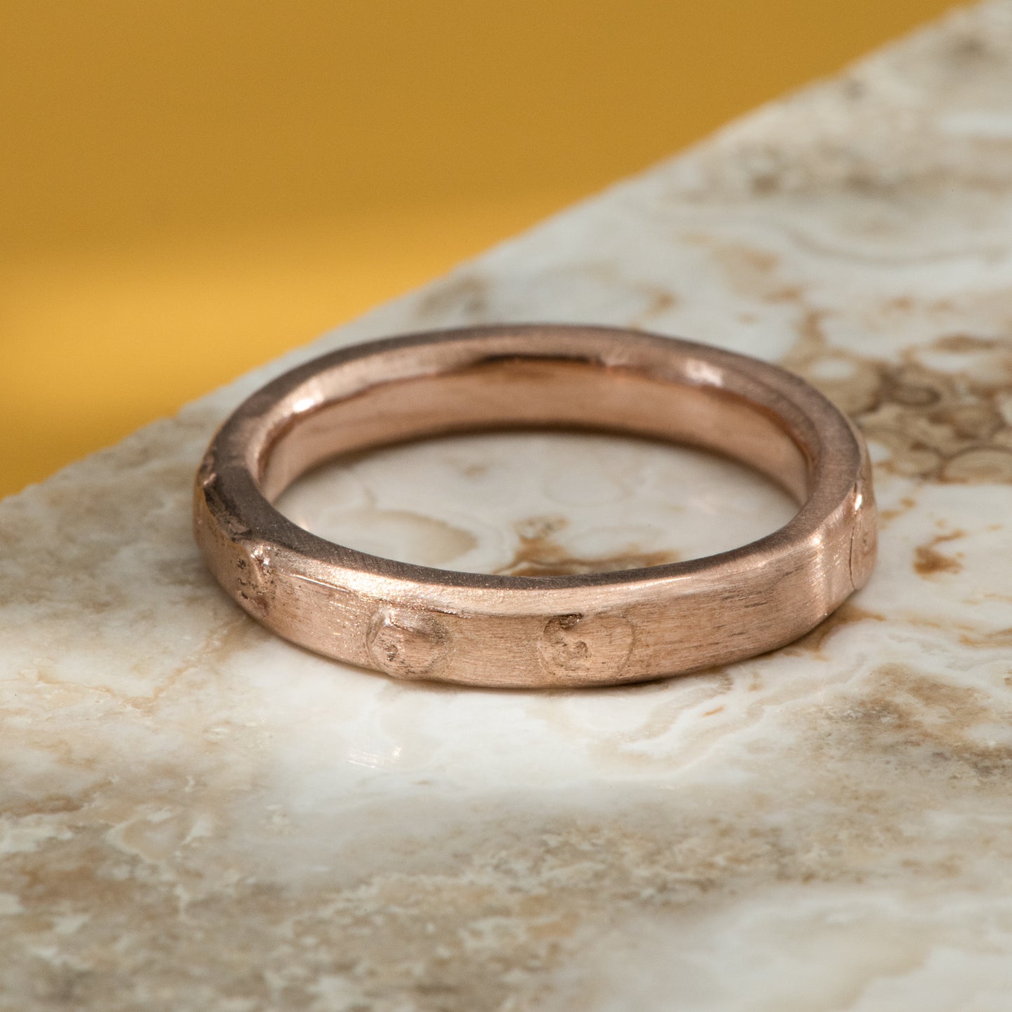 Satin finished rose gold band, with small burls all around the ring.