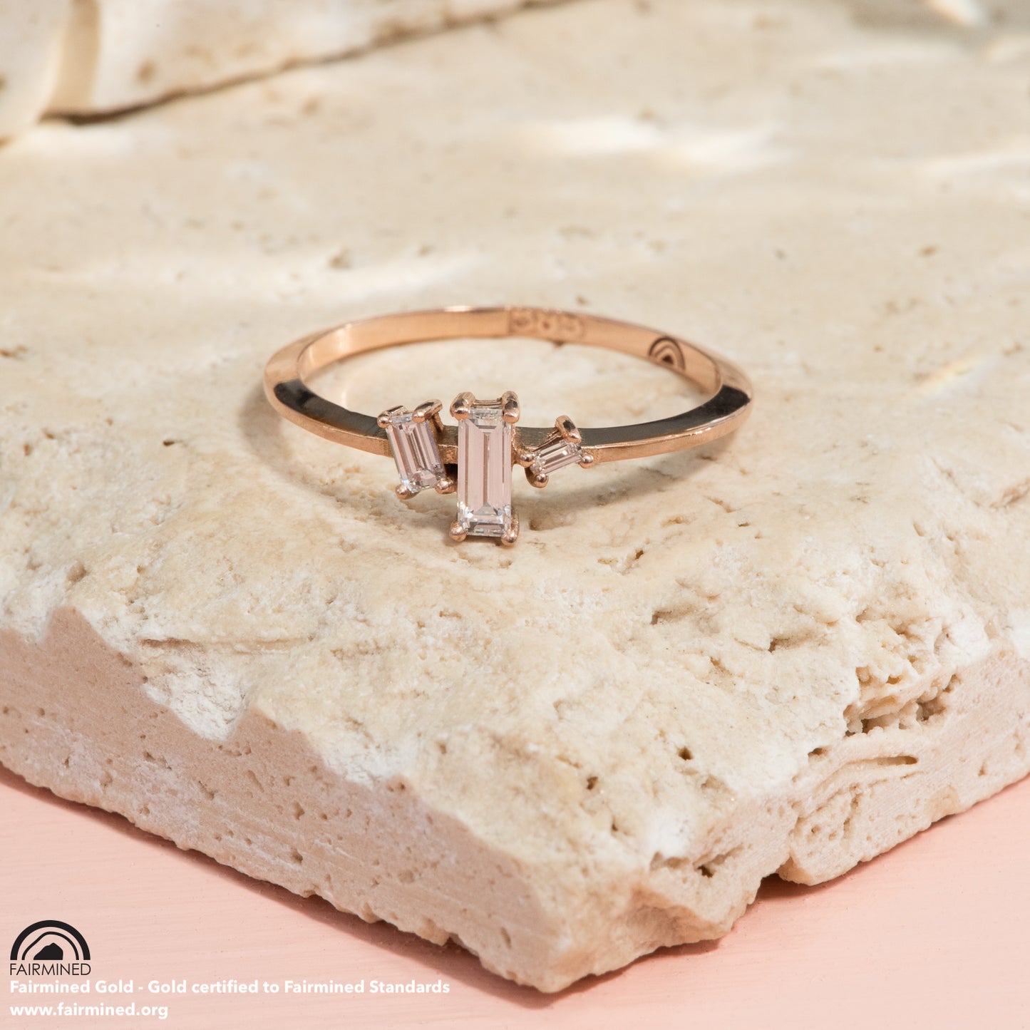 3 baguette cut diamonds sit asymmetrically on a polished rose gold band.