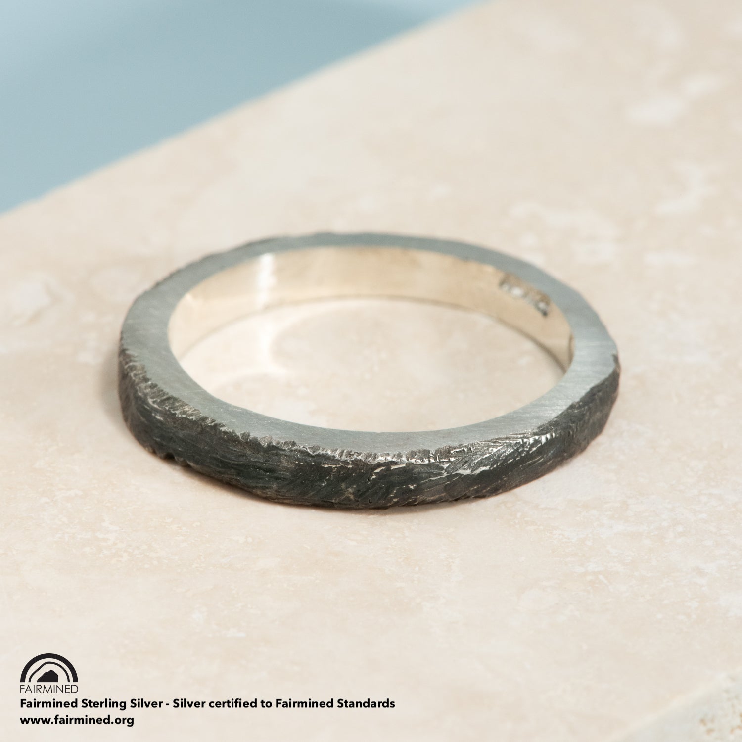 A silver ring with an oxidized brushed finish, and lightly polished high points.