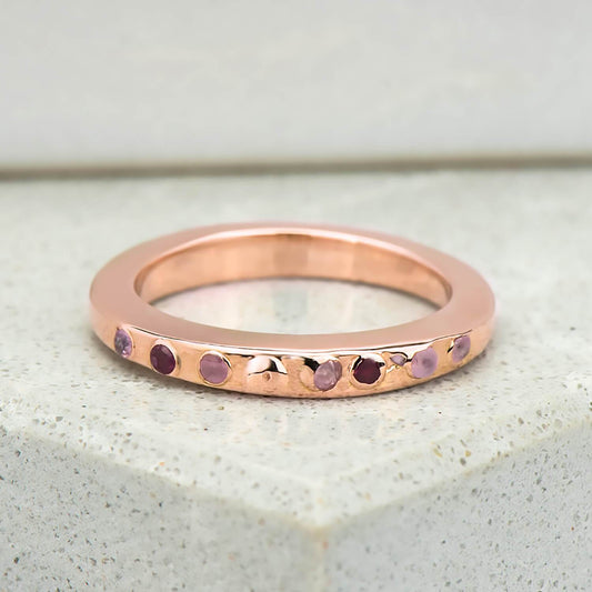 Recycled rose gold promise ring with eight natural pink sapphires in which have been set in cast. the band is approximately 3mm in width and has been finished to a mirror polish