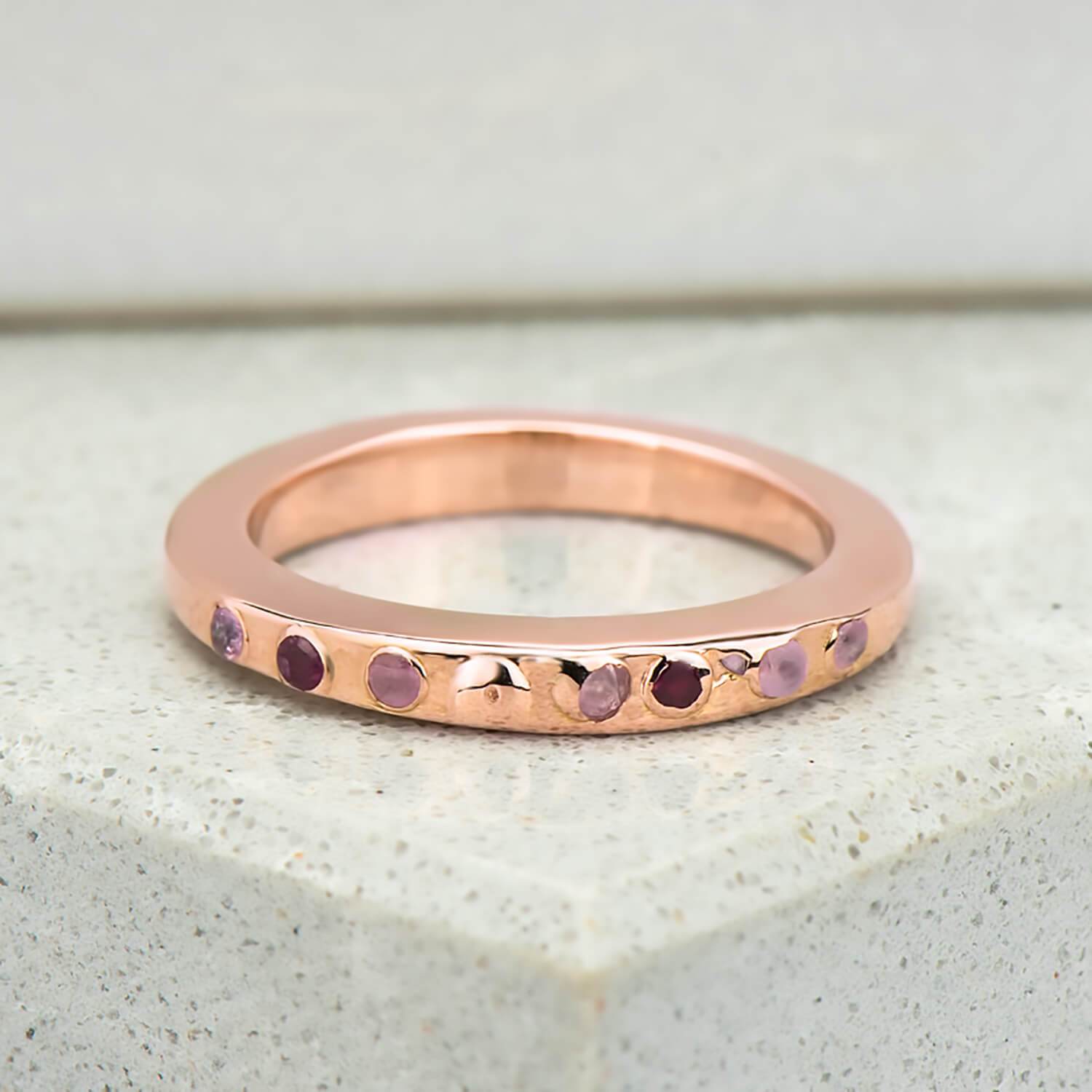 Recycled rose gold promise ring with eight natural pink sapphires in which have been set in cast. the band is approximately 3mm in width and has been finished to a mirror polish