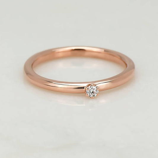 High polish 10 karat recycled rose gold band, with a 2 millimetre natural clear diamond in a six prong setting.