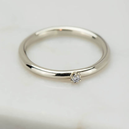 High polish 10 karat recycled white gold band, with a 2 millimetre natural clear diamond in a six prong setting.