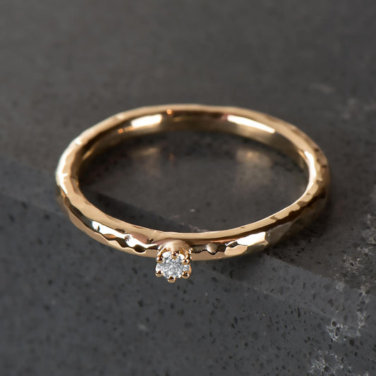 Hammered 10 karat recycled yellow gold band, with a 2 millimetre natural clear diamond in a six prong setting.