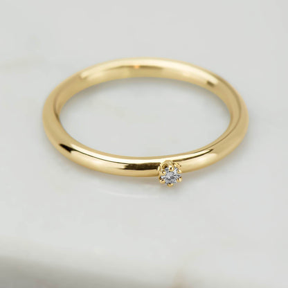 High polish 10 karat recycled yellow gold band, with a 2 millimetre natural clear diamond in a six prong setting.