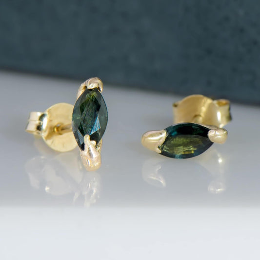 These studded earrings are made out of 14 karat yellow gold with 2 recycled natural marquise blue sapphires measuring 5.5mm x 2.5mm in which have been set in cast 