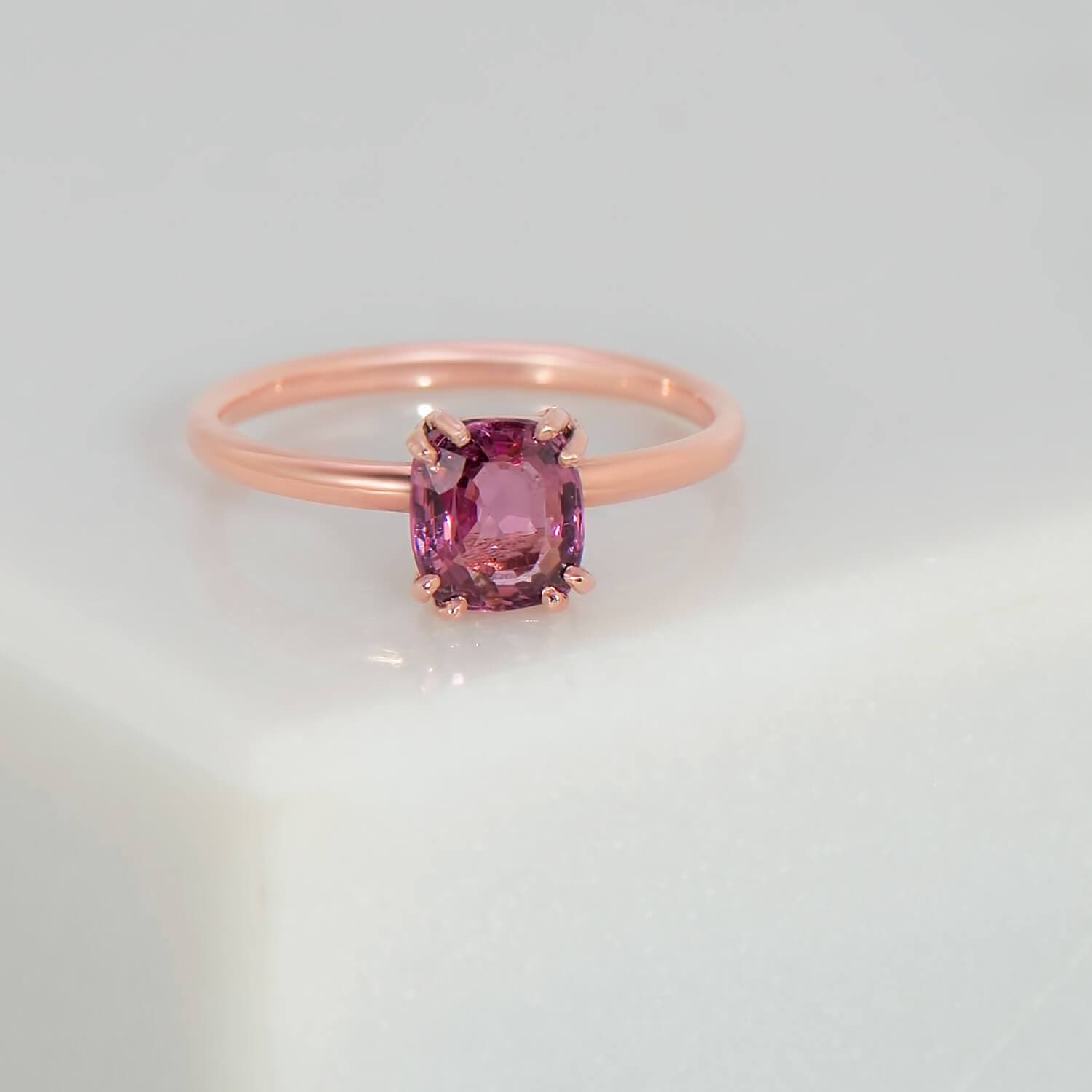 Recycled 14 rose gold solitaire engagement ring containing a 0.66 carat natural pink recycled spinel set in an eight prong setting. The band has been high polished with an oval profile with a width of 1.80mm and a thickness of 1.2mm.