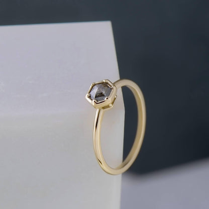 Recycled 14 karat yellow gold halo engagement ring with a 0.46 carat hexagon salt & pepper diamond. The band has an oval profile and has been brought to a high mirror finish.