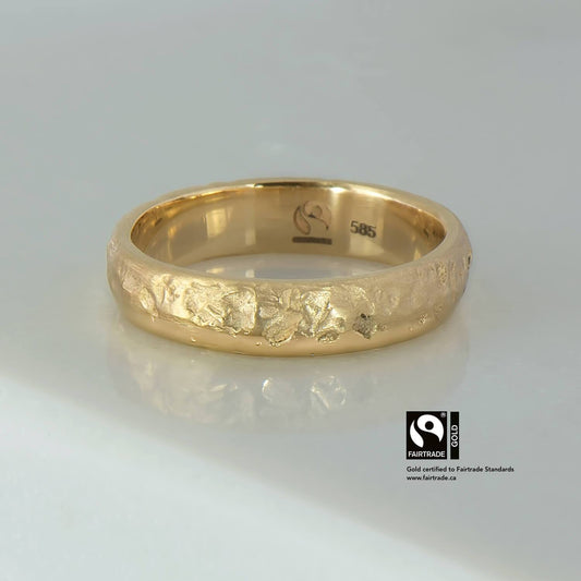 14 karat Fairtrade Certified gold wedding ring with a pitted texture on one side & polished bevel on the other. The ring is a half round profile measuring 5mm in width & 1.8mm in thickness.