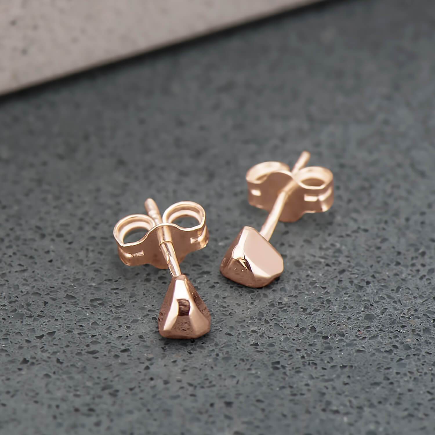 Recycled 10 karat rose gold studs, shaped like triangles and highly polished.