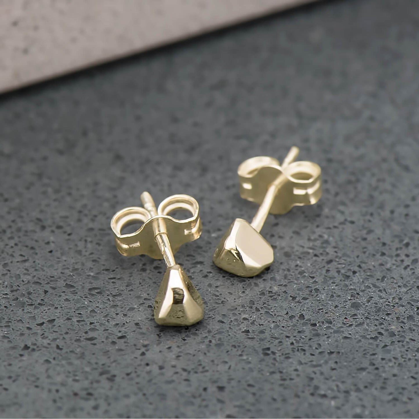 Recycled 10 karat yellow gold studs, shaped like triangles and highly polished.